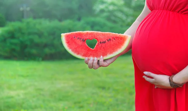 怀孕的女人拿着西瓜有选择的重点 — 图库照片