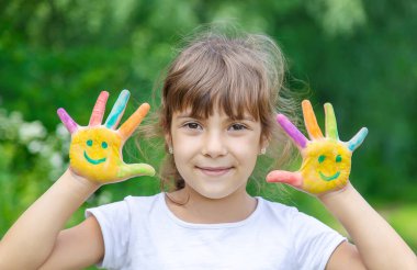 Çocuk eli, gülümsemeyi resmeder. Seçici odak.