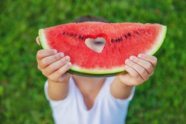 Piknikteki bir çocuk karpuz yer. Seçici odaklanma. Yiyecek..