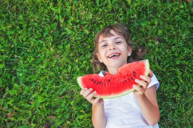 Piknikteki bir çocuk karpuz yer. Seçici odaklanma. Yiyecek..