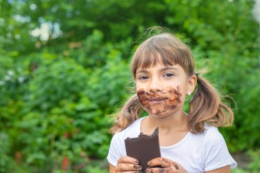 Çocuk bir çikolata yiyor. Seçici odaklanma. İnsanlar.