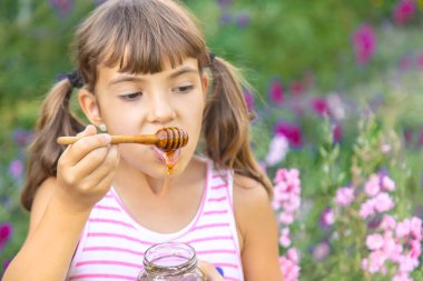 Çocuk ballı yaz fotoğrafı yiyor. Seçici odaklanma. Doğa.