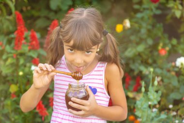 Çocuk ballı yaz fotoğrafı yiyor. Seçici odaklanma. Doğa.