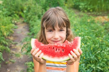 Piknikteki bir çocuk karpuz yer. Seçici odak.