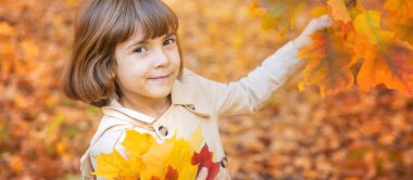 Sonbahar yapraklarıyla parktaki çocuklar. Seçici odak.