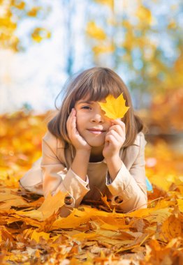 Sonbahar yapraklarıyla parktaki çocuklar. Seçici odak.