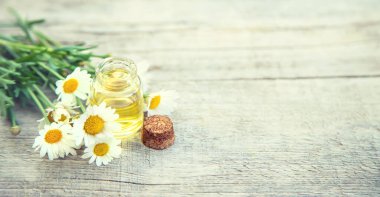 Papatya yağı küçük bir şişede. Seçici odaklanma. Doğa.