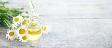 Papatya yağı küçük bir şişede. Seçici odaklanma. Doğa.