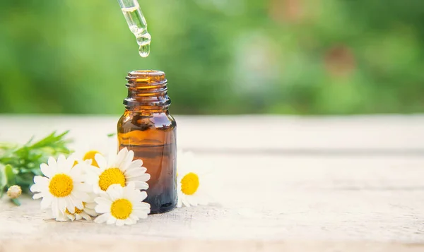 Chamomile essential oil in a small bottle. Selective focus. nature.