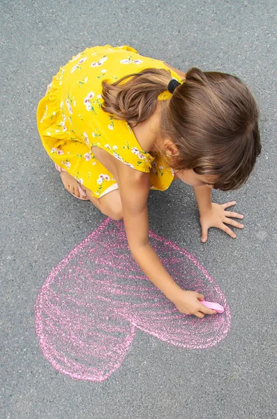 Das Kind Zeichnet Mit Kreide Ein Herz Auf Den Asphalt — Stockfoto