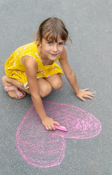 Das Kind Zeichnet Mit Kreide Ein Herz Auf Den Asphalt — Stockfoto