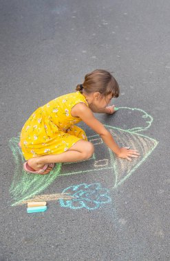 Çocuk asfalta bir ev çiziyor. Seçici odaklanma. Çocuk.