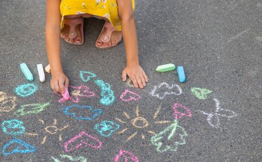 Çocuk asfalta tebeşirle çizer. Seçici odaklanma. Çocuk.