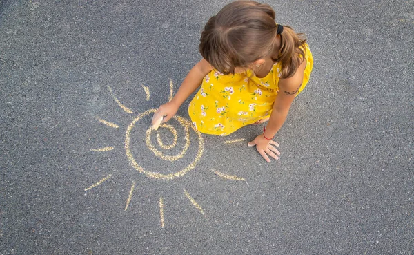 子供はアスファルトの上に太陽を描きます 選択的フォーカス — ストック写真