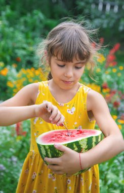 Çocuk kaşıkla karpuz yiyor. Seçici odak.