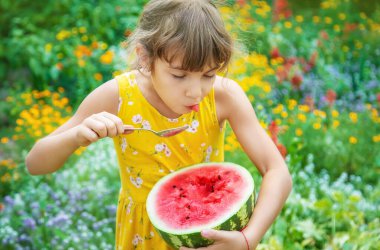 Çocuk kaşıkla karpuz yiyor. Seçici odak.