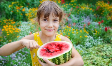 Çocuk kaşıkla karpuz yiyor. Seçici odak.