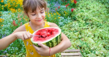 Çocuk kaşıkla karpuz yiyor. Seçici odak.