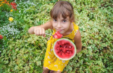 Çocuk kaşıkla karpuz yiyor. Seçici odak.