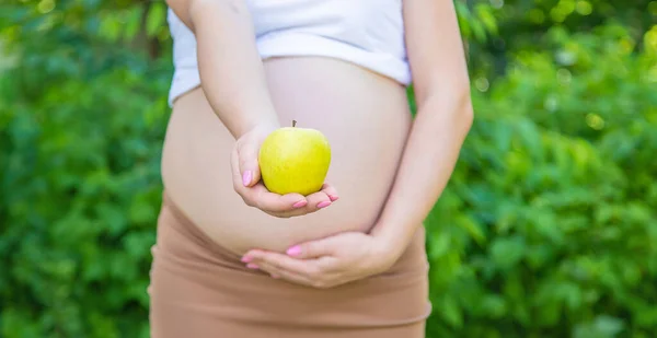 Zwangere Vrouw Met Een Appel Haar Handen Selectieve Focus Levensmiddelen — Stockfoto