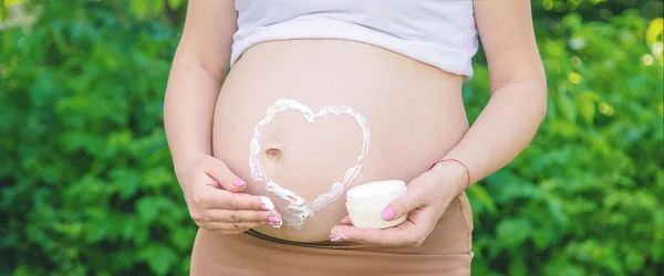 Gravid Kvinna Med Kräm För Bristningar Selektivt Fokus Natur — Stockfoto