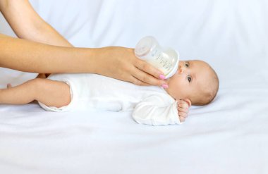 Anne yeni doğmuş bebeğini şişeden besliyor. Seçici odaklanma. Yiyecek..