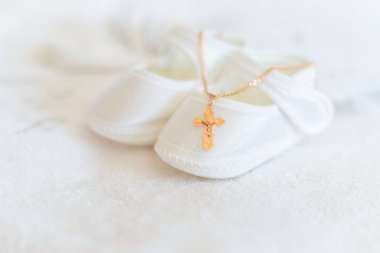 Bebeğin vaftiz töreni için giysi ve haç. Seçici odaklanma. Beyaz.