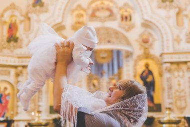 Annem bebeği kilisede tutuyor. Seçici odaklanma. İnsanlar.