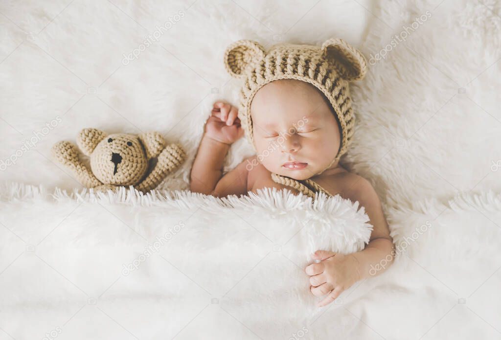 A newborn baby sleeps with a teddy bear. Selective focus. people.