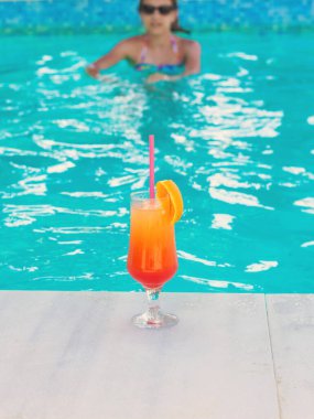 Havuzda kokteyl içen bir kadın. Seçici odaklanma. Kız.