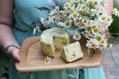 Suluguni peynir dereotu ve beyaz papatya ahşap bir masa üzerinde bir buket ile