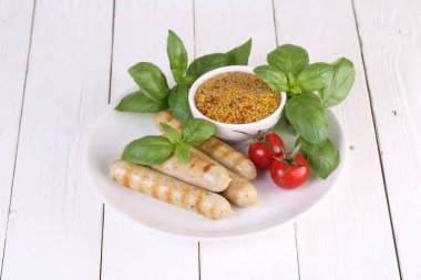 Domates, fesleğen ve hardal ile bir ızgarada pişmiş sosis