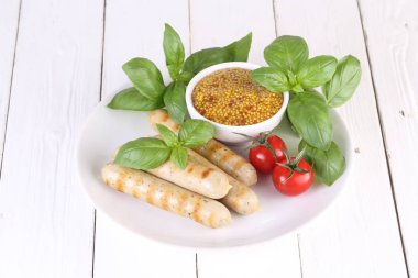 Domates, fesleğen ve hardal ile bir ızgarada pişmiş sosis