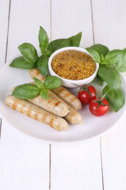 Domates, fesleğen ve hardal ile bir ızgarada pişmiş sosis