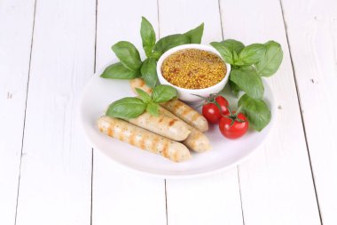 Domates, fesleğen ve hardal ile bir ızgarada pişmiş sosis