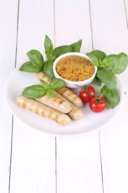 Domates, fesleğen ve hardal ile bir ızgarada pişmiş sosis