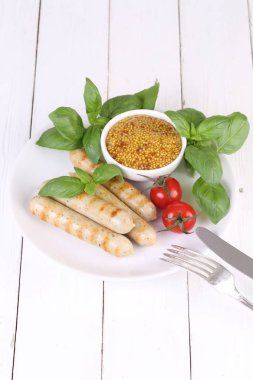 Domates, fesleğen ve hardal ile bir ızgarada pişmiş sosis