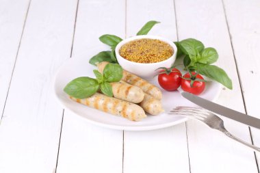 Domates, fesleğen ve hardal ile bir ızgarada pişmiş sosis