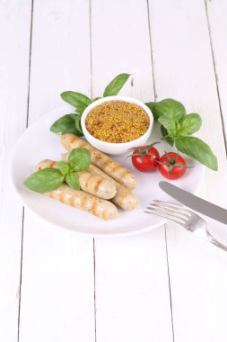 Domates, fesleğen ve hardal ile bir ızgarada pişmiş sosis