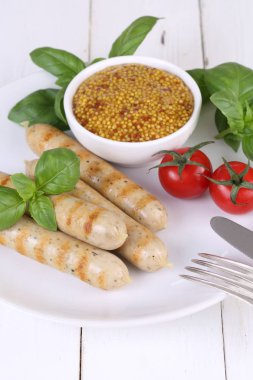 Domates, fesleğen ve hardal ile bir ızgarada pişmiş sosis