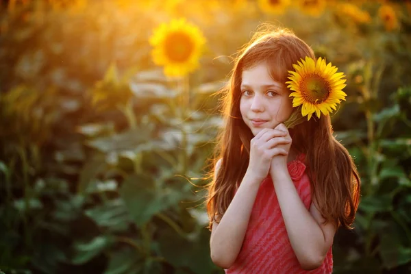 Kız bir ayçiçeği tutuyor