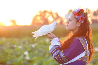 beyaz bir güvercin çiçek çelenk kız tutar