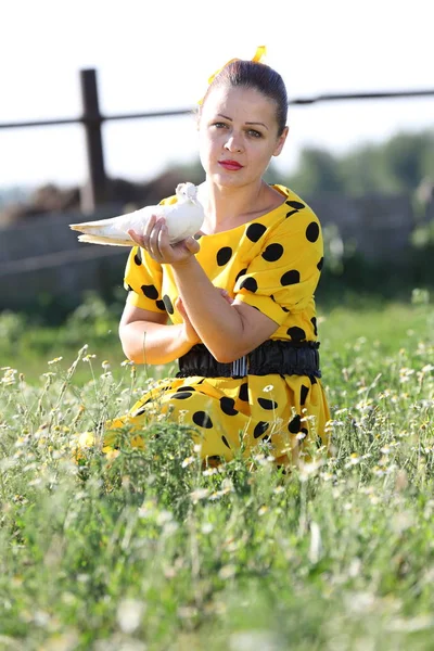 Beyaz bir güvercin tutan güzel kız