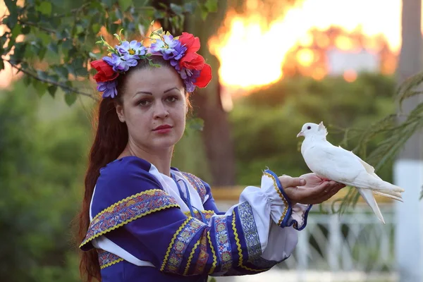 beyaz bir güvercin çiçek çelenk kız tutar