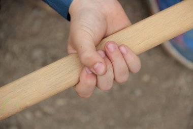 Çocuğun elinde bir sopa tutun. Bir çocuğun elinde bir sopa