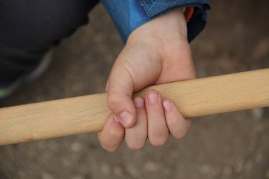 Çocuğun elinde bir sopa tutun. Bir çocuğun elinde bir sopa