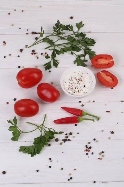 Tomatoes with spices on a white background