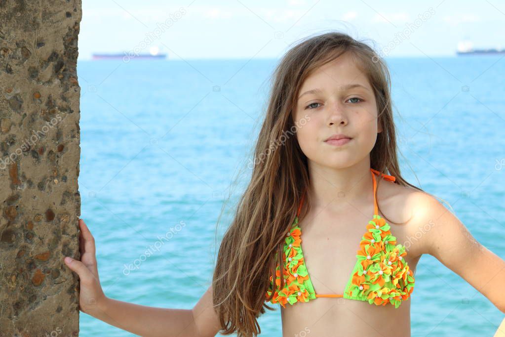 A girl in a bathing suit on the background of the sea