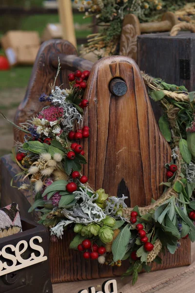 Wooden box with a decorative wreath of herbs and berries