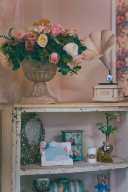 Eski bir raf üzerinde yapay çiçekler
